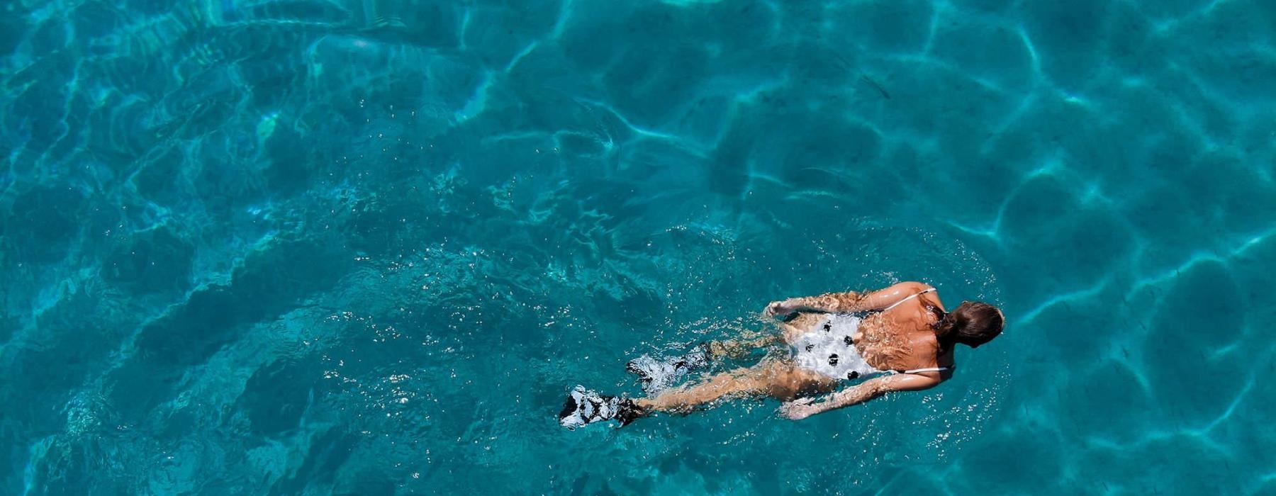 overhead shot of a woman swimming in a pool